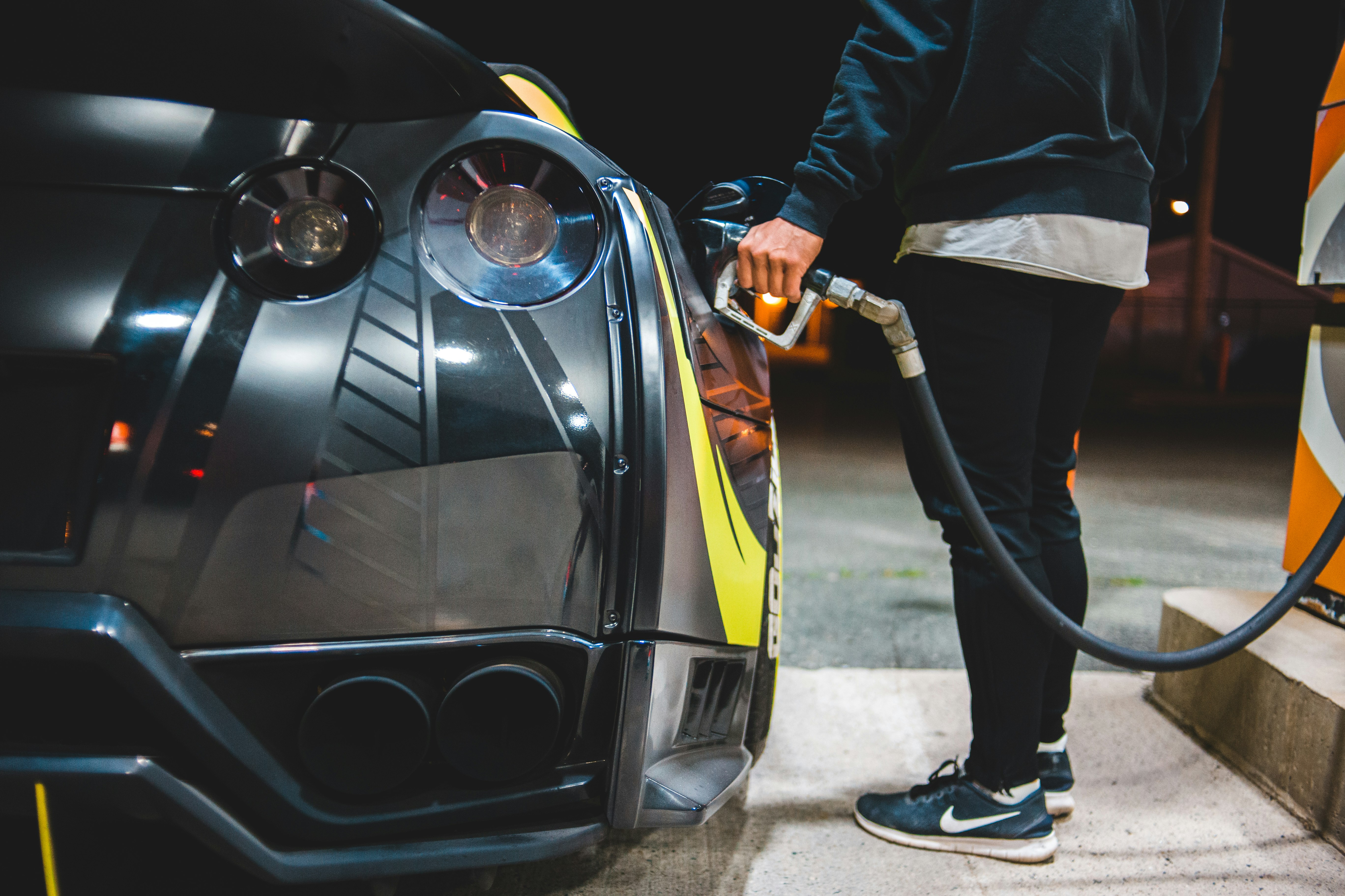 man in black jacket and black pants standing beside black car